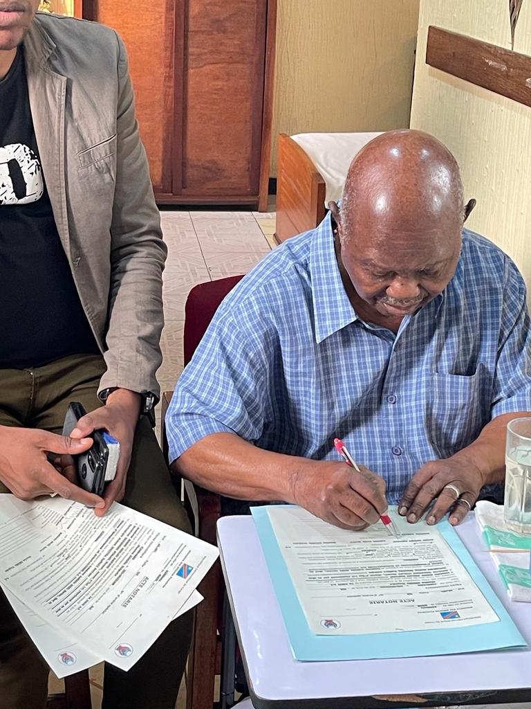 Monsieur Mampengu Hubert Bernard, vendeur, en train de signer l'acte de vente