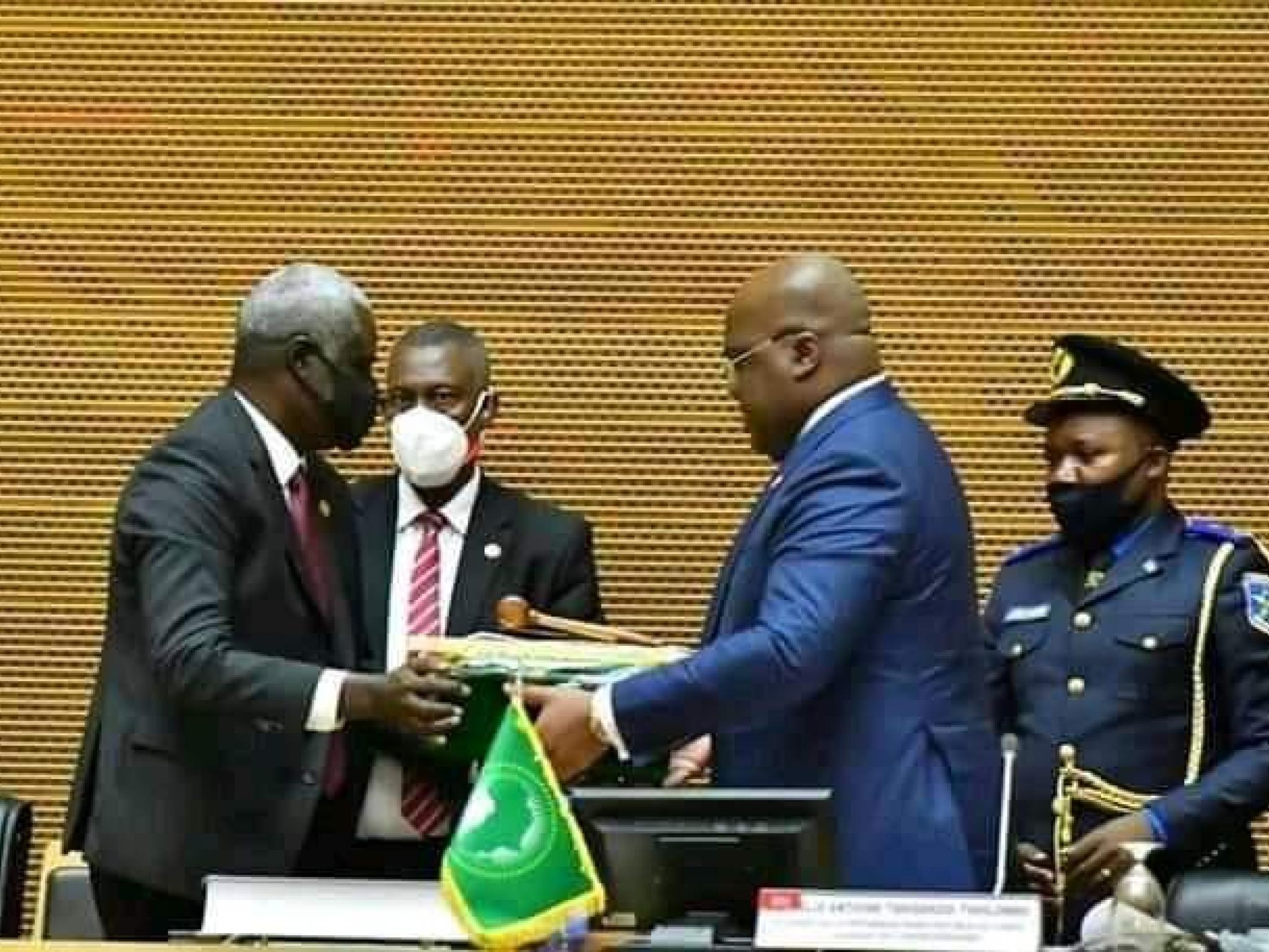 Le Président de la Commission de l'Union Africaine, Moussa Fakhi (à gauche) remet la charte de l'Union Africaine à son  nouveau président, Félix Tshisekedi (à droite)