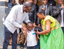 Le député national Éric Tshikuma remet à un élève l’une des 48 bourses « Patrick Muyaya », comprenant un kit scolaire ainsi que la prise en charge des frais de scolarité pour l’année scolaire 2026-2027.