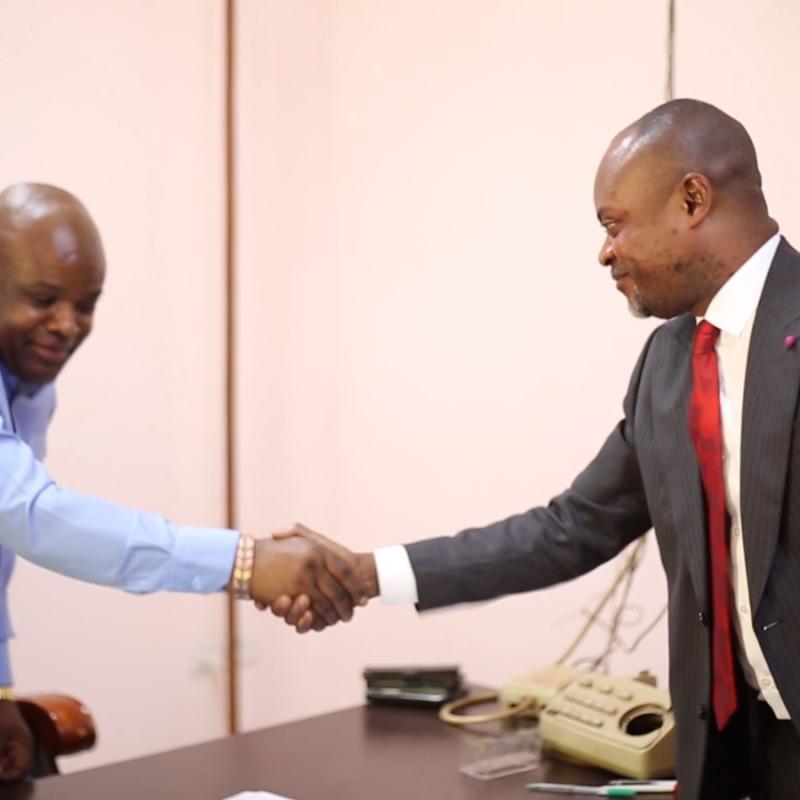Poignée de main entre Gilbert Mwamba Mwamba, nouveau Procureur de la République près le Parquet de Grande Instance de Kolwezi, et son prédécesseur, Steve Mutombo Kalubi, lors de la cérémonie de remise et reprise