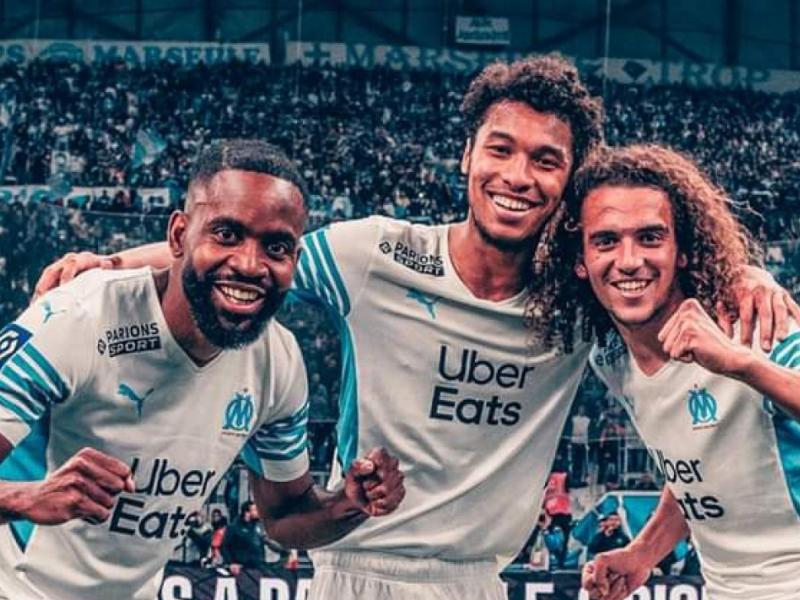 Cédric Bakambu en pleine célébration avec ses coéquipiers de l'OM, Kamara et Guendouzi.