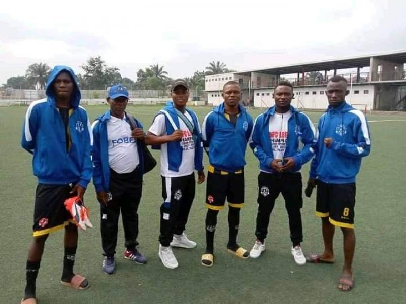 De gauche à droite, à la deuxième et troisième position, l'entraîneur de l'équipe et le préparateur physique, entourés des joueurs du club