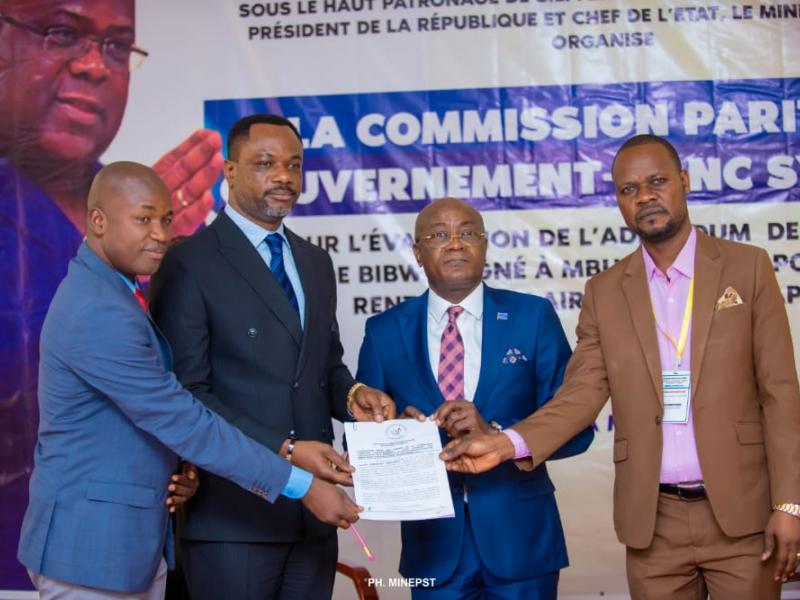 Le ministre de l'EPST, le professeur Tony Mwaba, représentant le gouvernement et les délégués syndicaux des enseignants brandissant le nouvel accord de Mbuela Lodge