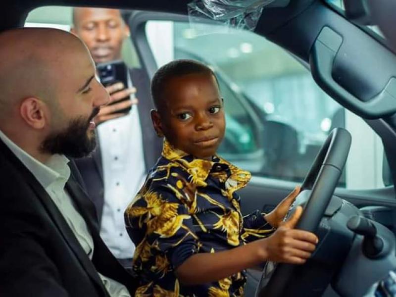 Le petit Junior (à droite) assis au volant de la Jeep aux côtés du millionnaire libanais Abed Achour