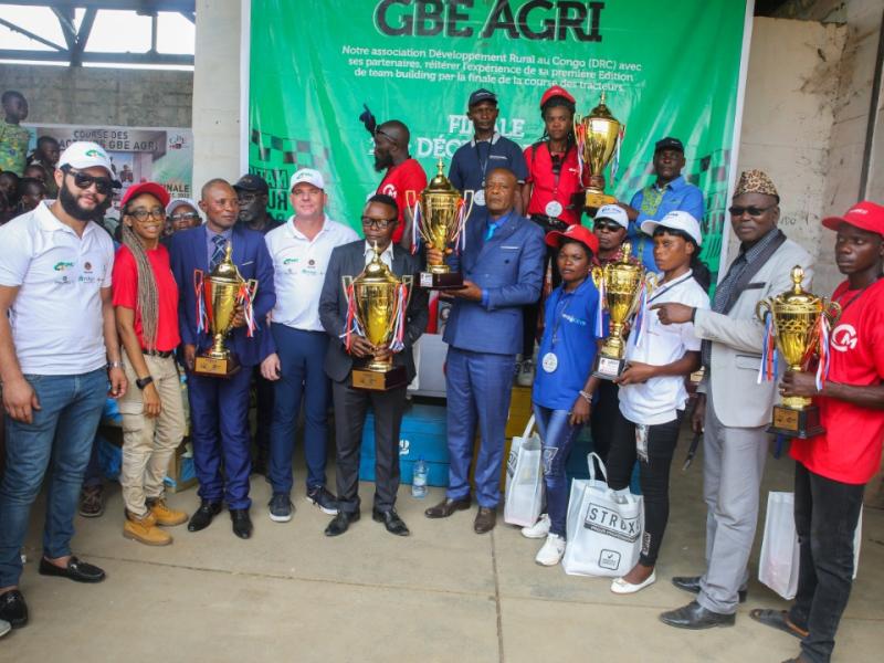 Les vainqueurs de la première édition de la finale de la course des tracteurs dans la province de Mongala, à Binga, entouré du président du Blatner Elwyn Agri