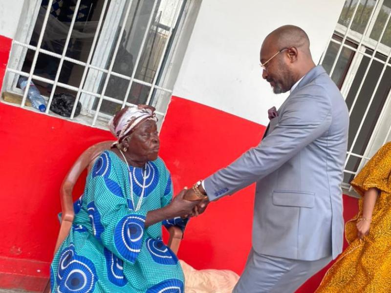 Jésus-Noël Sheke serrant très fort les bras d'une vieillarde au home des vieillards de Kabinda à Kinshasa