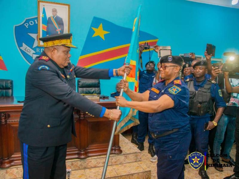 Le nouveau Commissaire provincial de Kinshasa, le Général Blaise Mbula Kilomba Limba reçoit le flambeau (drapeau du pays) des mains du commissaire Général de la police, le Général Patience Mushid Yav.
