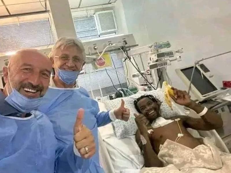 Jonathan Bolingi sur son lit d'hôpital, aux côté de son médecin et son manager.