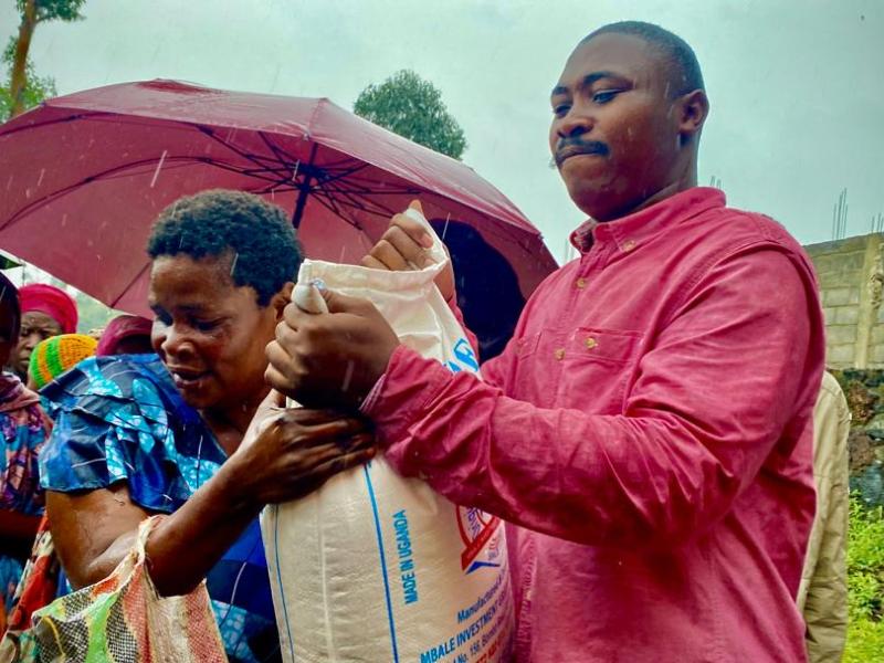 Espoir Mwimuka, activiste des droits de l'homme est en train de remettre un sac de farine à une femme déplacée [photo d'illustration]