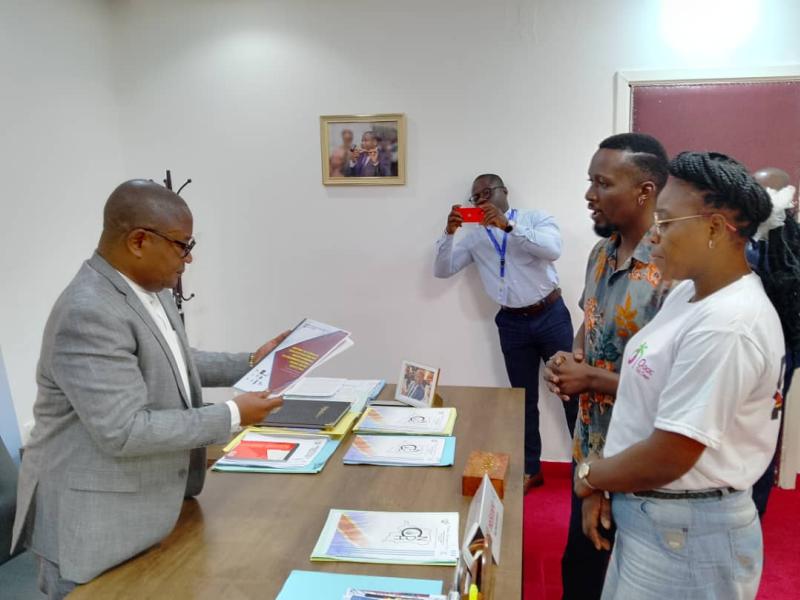 Le président du CNDH, Paul Nsapu, recevant le rapport de la communauté LGBT