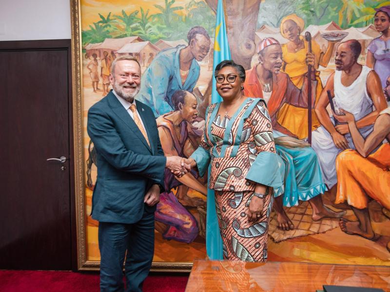 Poignée de main entre la Première Ministre Judith Suminwa Tuluka et le ministre britannique des Affaires Étrangères  pour l'Afrique, Lord Ray Collins