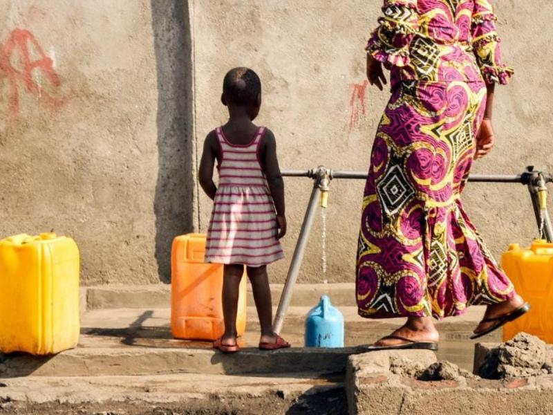 Une femme et son enfant remplissent des récipients à une pompe à eau appartenant à la Regideso dans la ville de Goma [photo d’illustration]