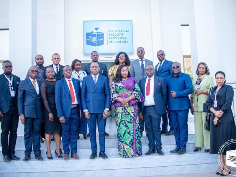 Le Président de la CENI Denis Kadima pose avec quelques responsables de la centrale électorale devant le nouveau bâtiment administratif de la CENI au Lualaba