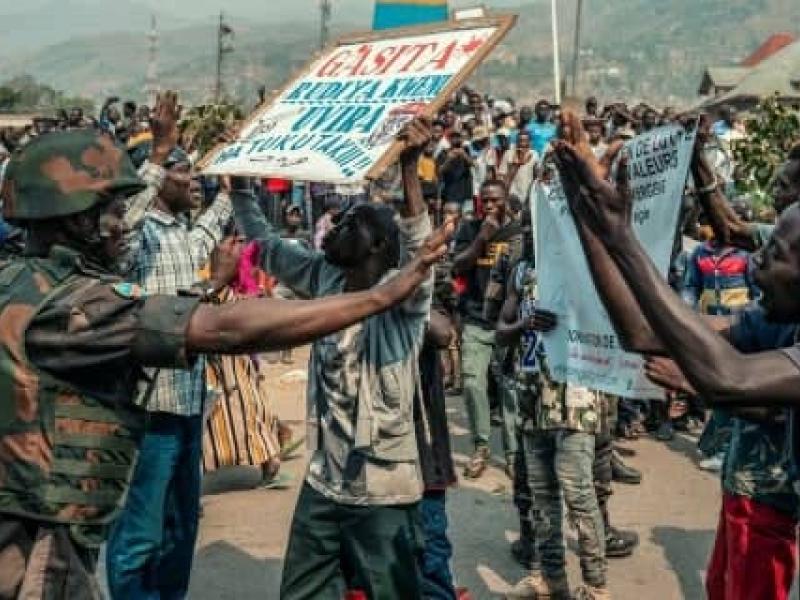 Un militaire congolais tente de calmer des manifestants en colère qui réclament le départ du général Olivier Gasita à Uvira.