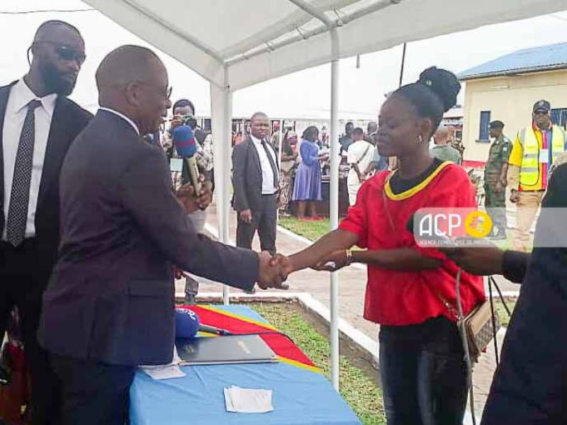 Le ministre de la justice Guillaume Ngefa serrant la main d'une bénéficiaire de la liberté conditionnelle