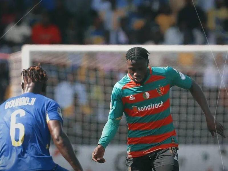 Un défenseur de Lupopo en face à face avec l'attaquant du MC Alger.