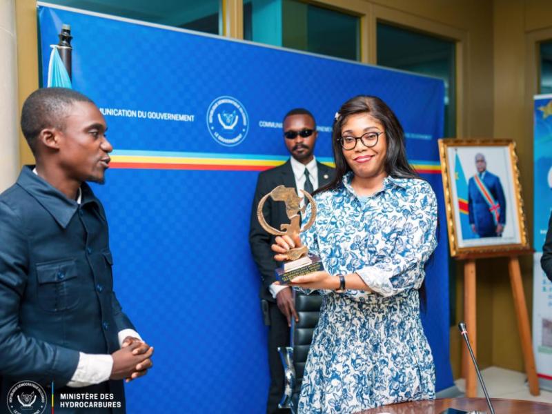 Acacia Bandubola, ministre des Hydrocarbures et le chef de la délégation de l'Association Jeunesse 242, lors de la remise du trophée et le diplôme de mérite.