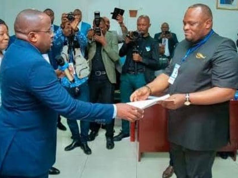 Daniel Bumba recevant le document d’orientation des mains du VPM lors d’une cérémonie à Kinshasa