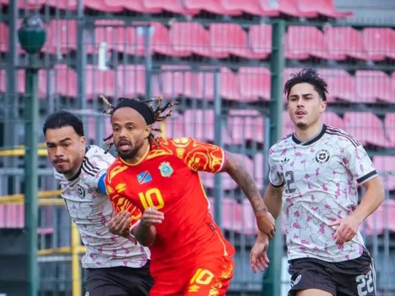 Le milieu du terrain congolais Théo Bongonda en duel avec deux joueurs chiliens.