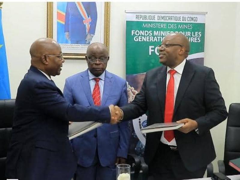 Poignet de main entre le DG sortant Faustin Biringanine et celui entrant Godard Motemona lors de la cérémonie de remise et reprise