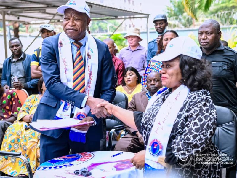 Poignée de main entre Irène Esambo, ministre déléguée en charge des PVH-APV, et le Secrétaire permanent de l'Union Sacrée de la Nation, André Mbata