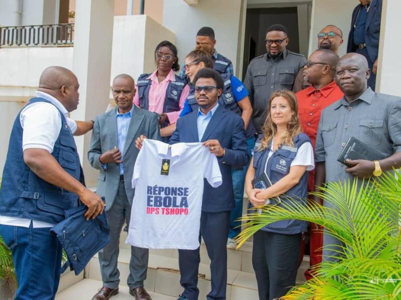 Le gouverneur de province, Paulin Lendongolia (au centre), présente un t-shirt symbolique de la riposte estampillé « Réponse Ebola DPS Tshopo », aux côtés de la délégation de l’OMS [photo d'illustration]