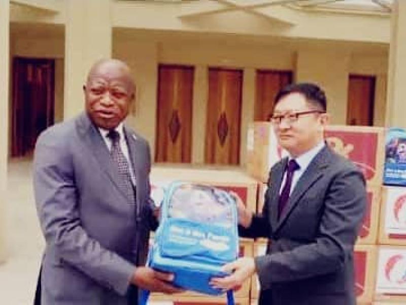 L’ambassadeur de Chine en RDC et le secrétaire permanent de l’USN, le professeur André Mbata, présentent un kit scolaire destiné aux élèves congolais.