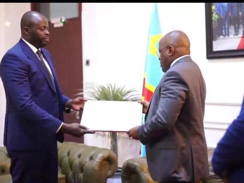 Le VPM en charge de l'Intérieur Jacquemain Shabani Lukoo recevant des mains des étudiants et chercheurs congolais établis en Belgique, un diplôme d'excellence