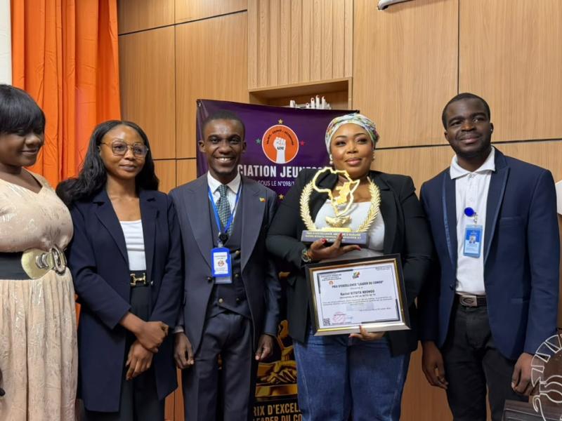 Rachel Kitsita Ndongo, directrice générale d’Actu30 TV, pose avec son diplôme de mérite aux côtés des membres de l’Association Jeunesse 242.