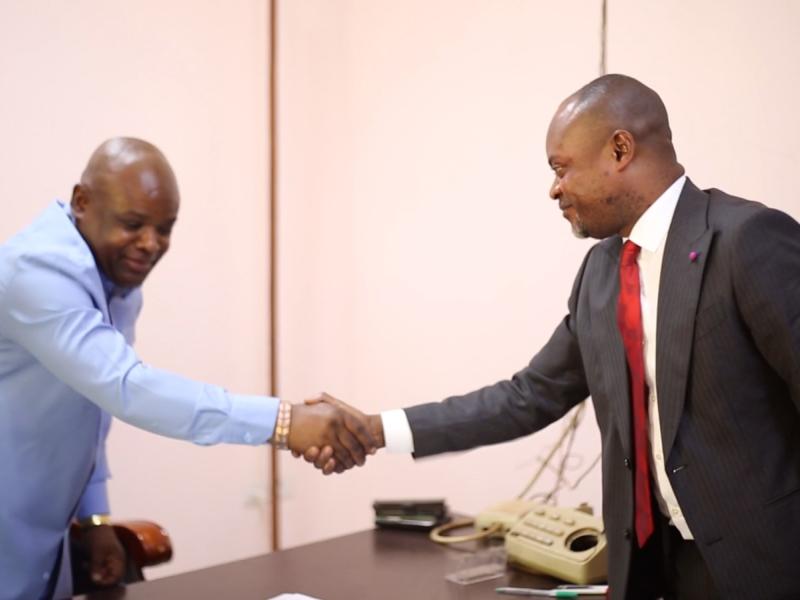 Poignée de main entre Gilbert Mwamba Mwamba, nouveau Procureur de la République près le Parquet de Grande Instance de Kolwezi, et son prédécesseur, Steve Mutombo Kalubi, lors de la cérémonie de remise et reprise