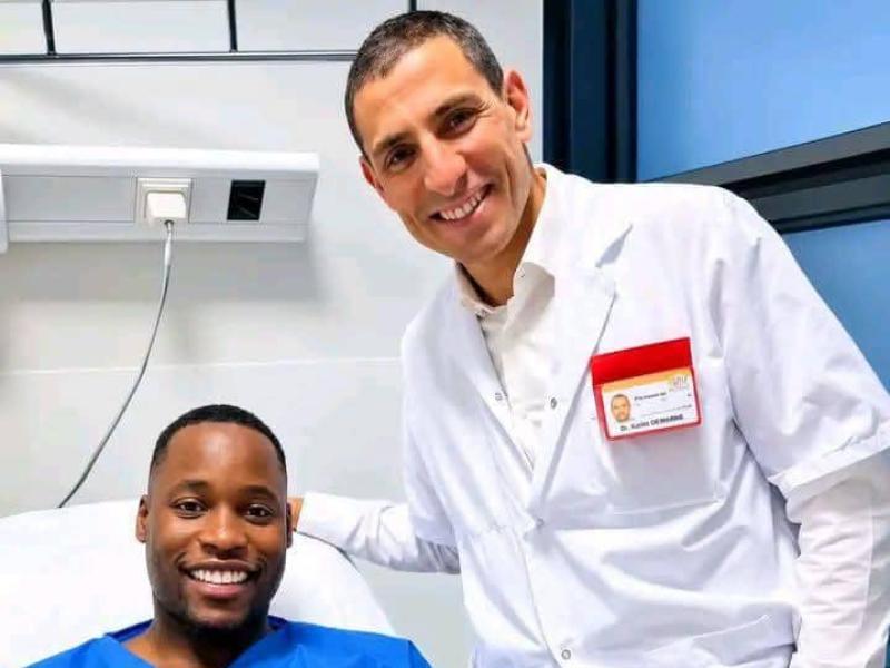 Lionel Mpasi sur un lit d'hôpital après les examens sur sa blessure