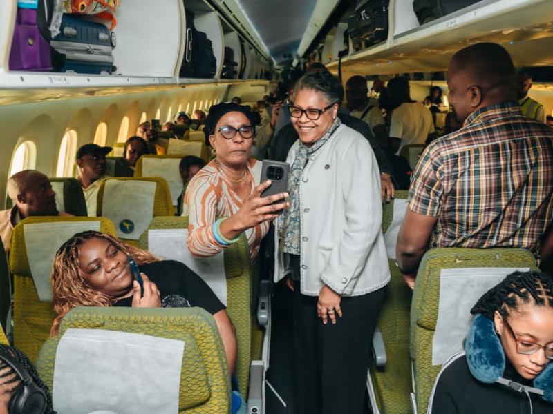 À bord de l’Airbus A330-900 d’Air Congo, la Première ministre Judith Suminwa Tuluka affiche un large sourire aux côtés d’autres passagers et se réjouit de la qualité du service à bord de la compagnie nationale, sur le chemin de New York.