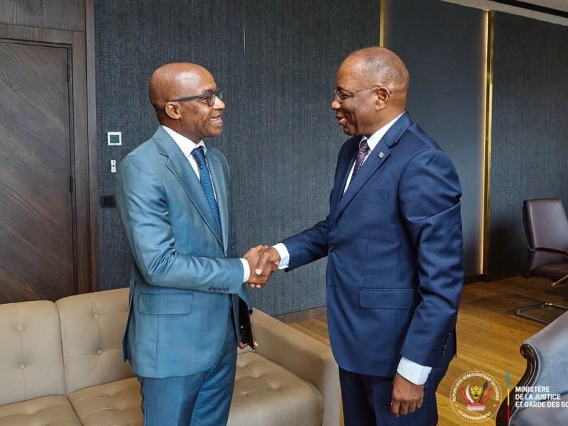 Poignée de mains entre Patrice Vahard, Directeur pays du BCNUDH en RDC (à gauche) et Guillaume Ngefa, ministre de la Justice et Garde des Sceaux en RDC (à droite)