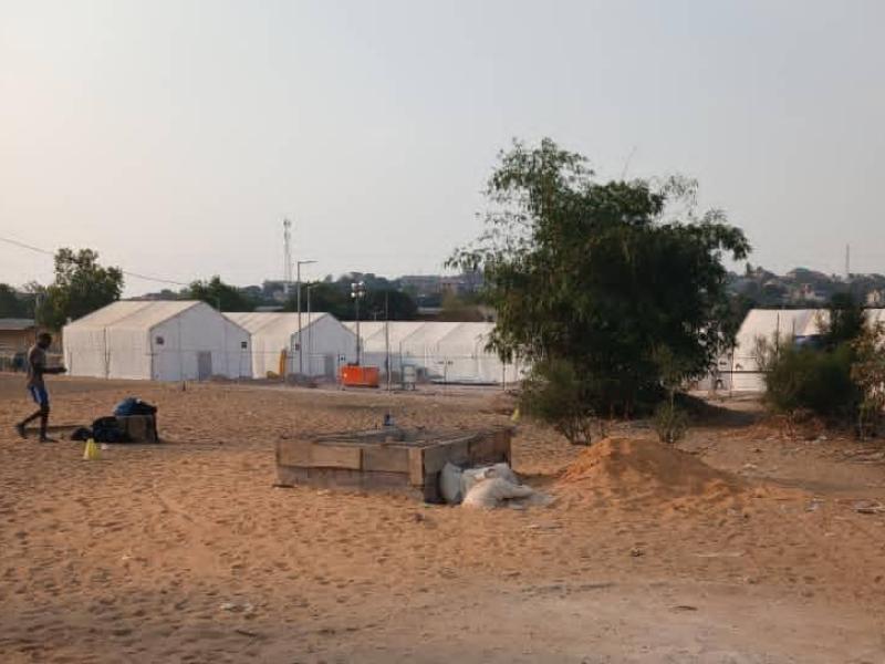 Aperçue d'une partie du terrain de football du Camp Badiadingi avec de tentes plantées exprimant le début de travaux sur place
