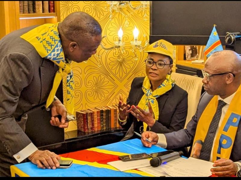 Nharly Amisi KM, coordonnateur du PPRD/Europe et S.E.F. du PPRD/France, entouré de deux membres du parti.