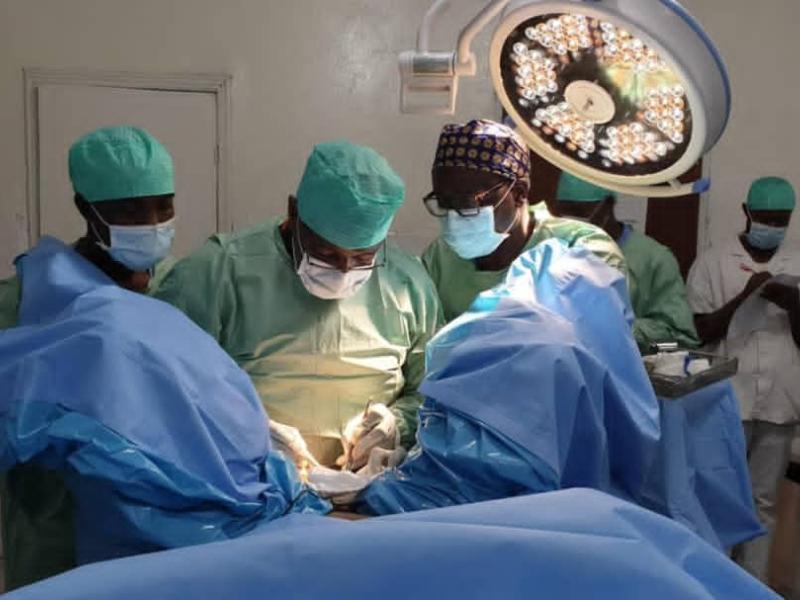 Médecin et assistants effectuant une chirurgie [Photo d'illustration]