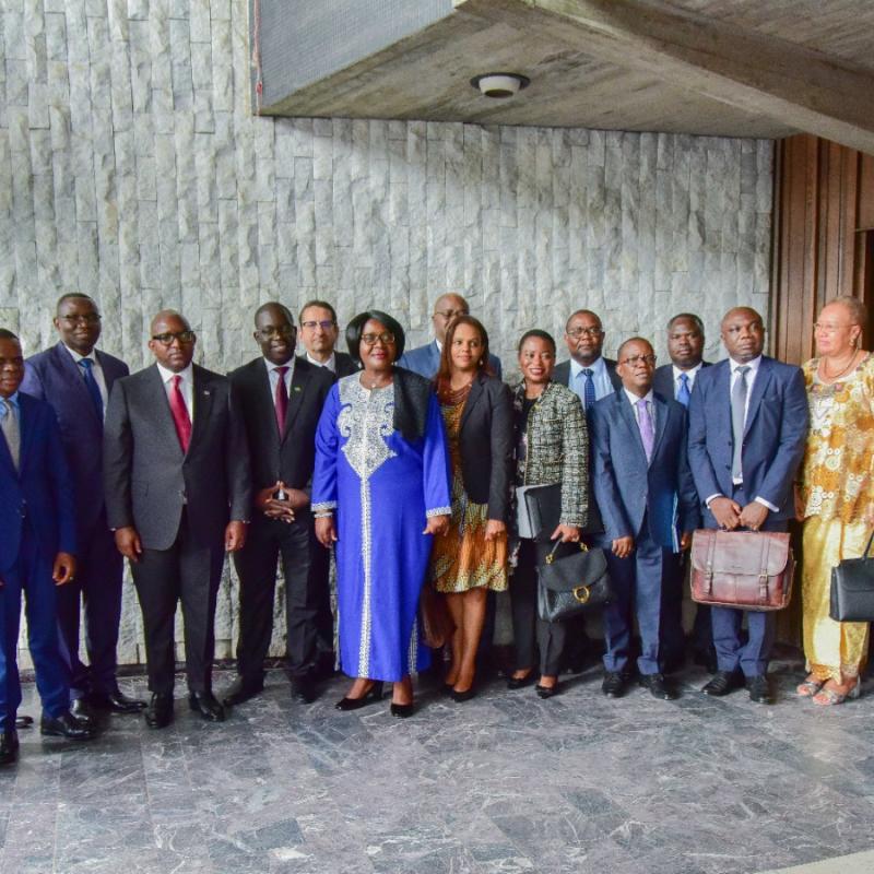 Photo de famille réunissant le Chef du Gouvernement, le ministre Julien Paluku, la délégation zambienne et les parties prenantes au projet de chaîne de valeur des batteries et véhicules électriques