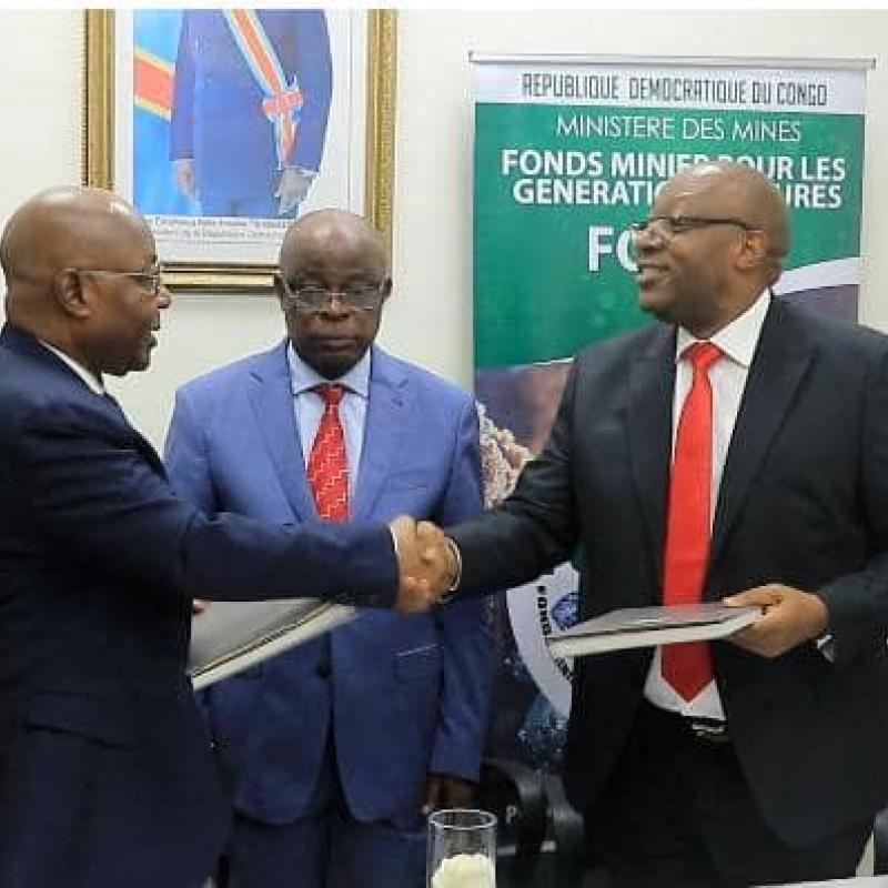 Poignet de main entre le DG sortant Faustin Biringanine et celui entrant Godard Motemona lors de la cérémonie de remise et reprise