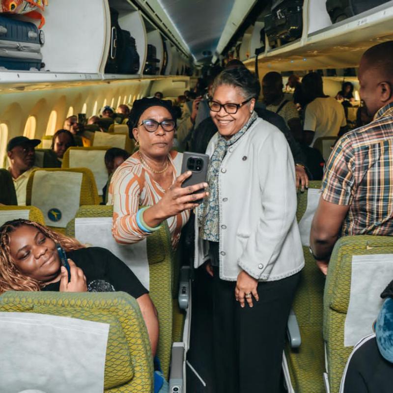 À bord de l’Airbus A330-900 d’Air Congo, la Première ministre Judith Suminwa Tuluka affiche un large sourire aux côtés d’autres passagers et se réjouit de la qualité du service à bord de la compagnie nationale, sur le chemin de New York.