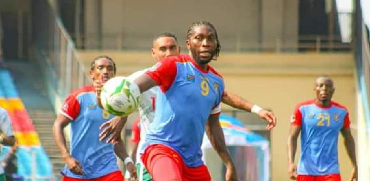 Dieumerci Mbokani en duel avec un joueur de Madagascar, lors des éliminatoires du mondial Qatar 2022.