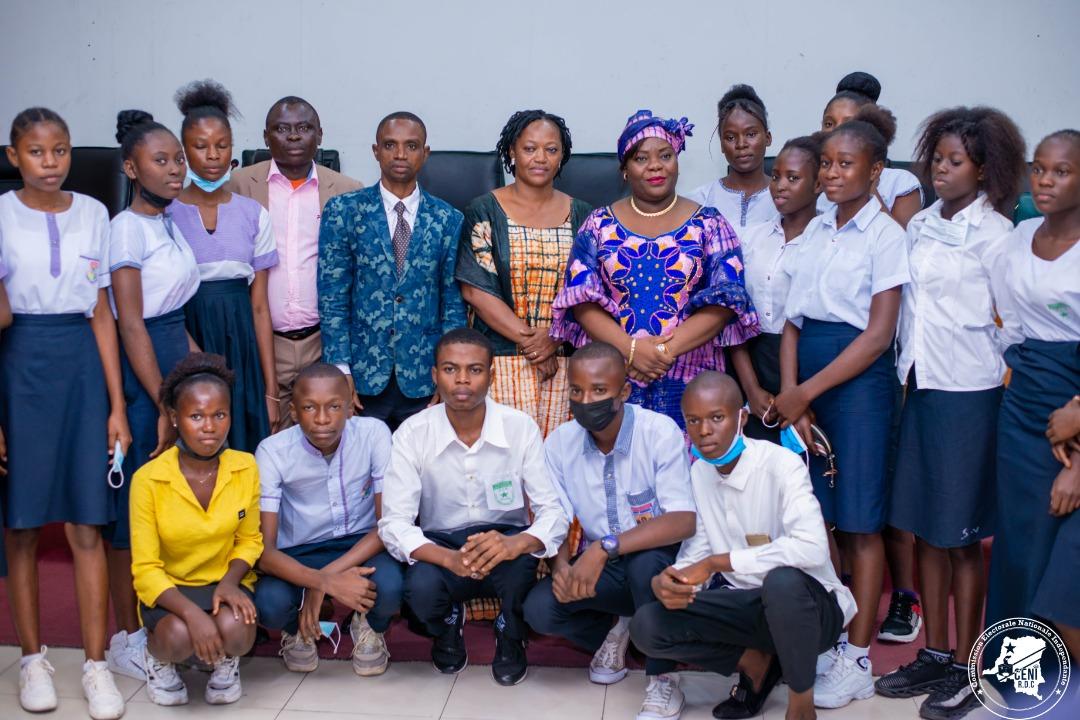 Photo de famille prise au siège de la CENI à l'issue d'une causerie entre Mme Aline d'Or Omokok, membre de la plénière, et les jeunes filles sur le processus électoral