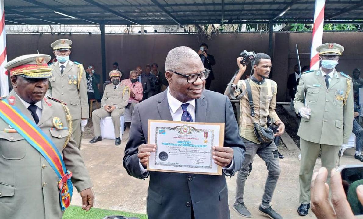 Le professeur Luzolo Bambi Lessa, Ex- Conseiller Spécial du président Kabila chargé de la lutte contre la corruption et blanchiment des capitaux, recevant son diplôme de mérite civique délivré par la Chancellerie des ordres nationaux