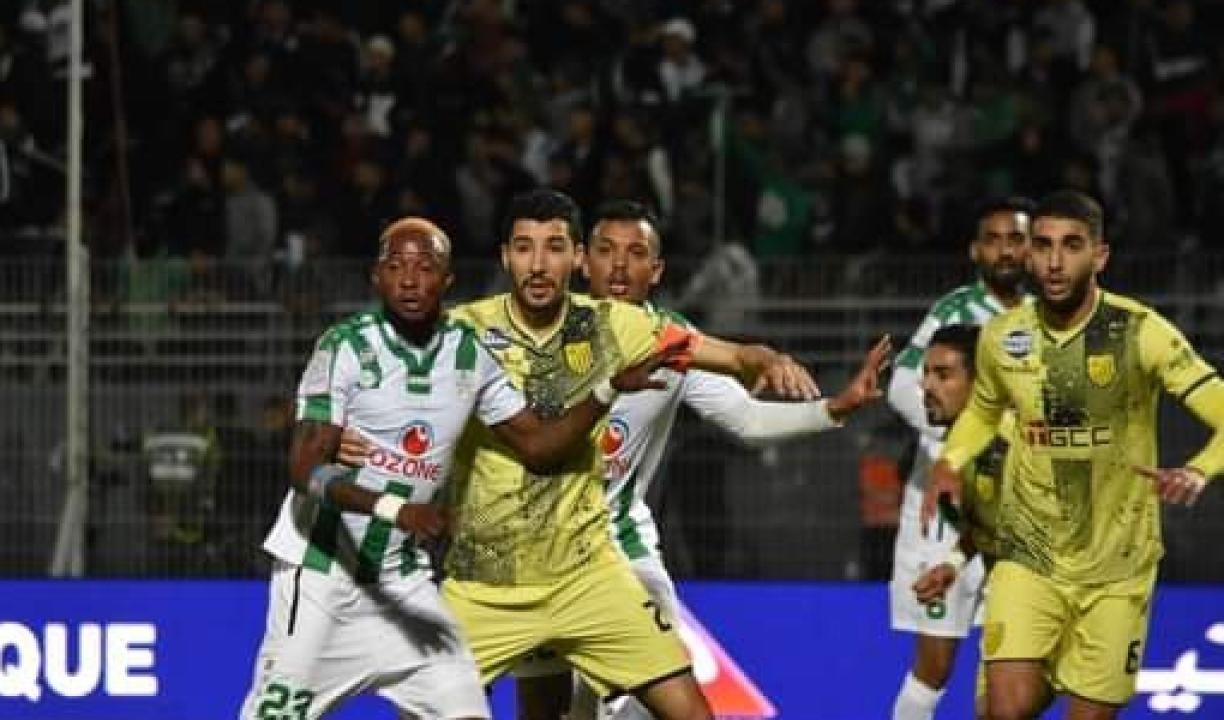 Dieumerci Mukoko Amale en duel avec un joueur de Maghreb Fes, dans la surface de réparation.