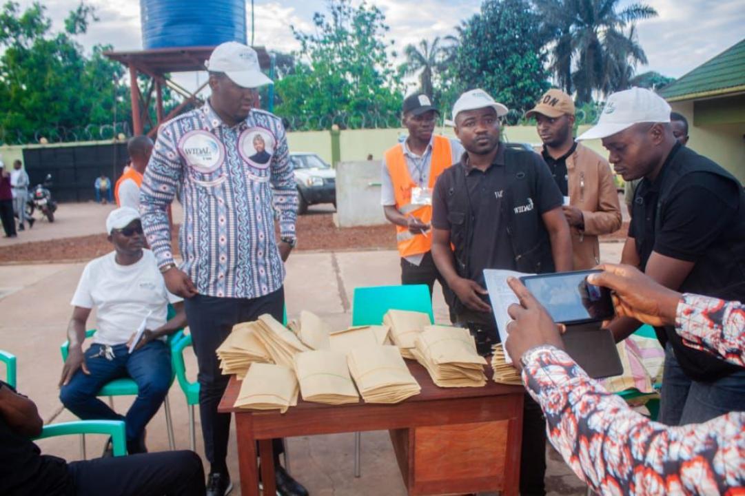 L'équipe de la Fondation Widal en train de servir les enveloppes aux vendeurs de Mbandaka