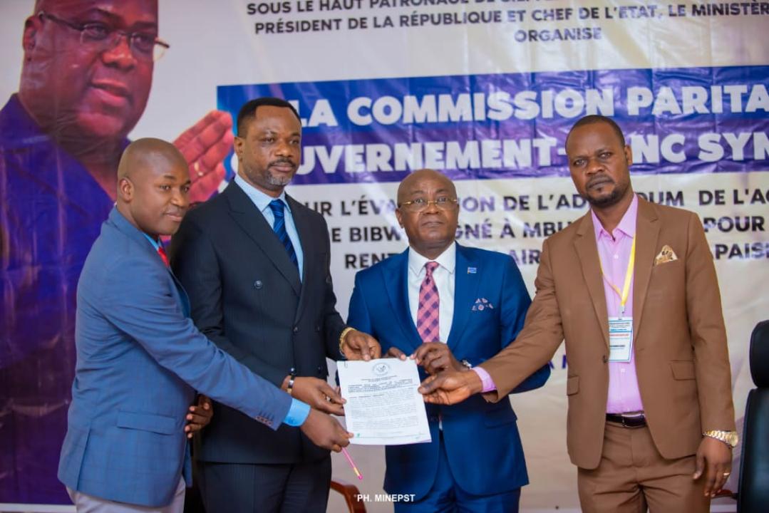 Le ministre de l'EPST, le professeur Tony Mwaba, représentant le gouvernement et les délégués syndicaux des enseignants brandissant le nouvel accord de Mbuela Lodge