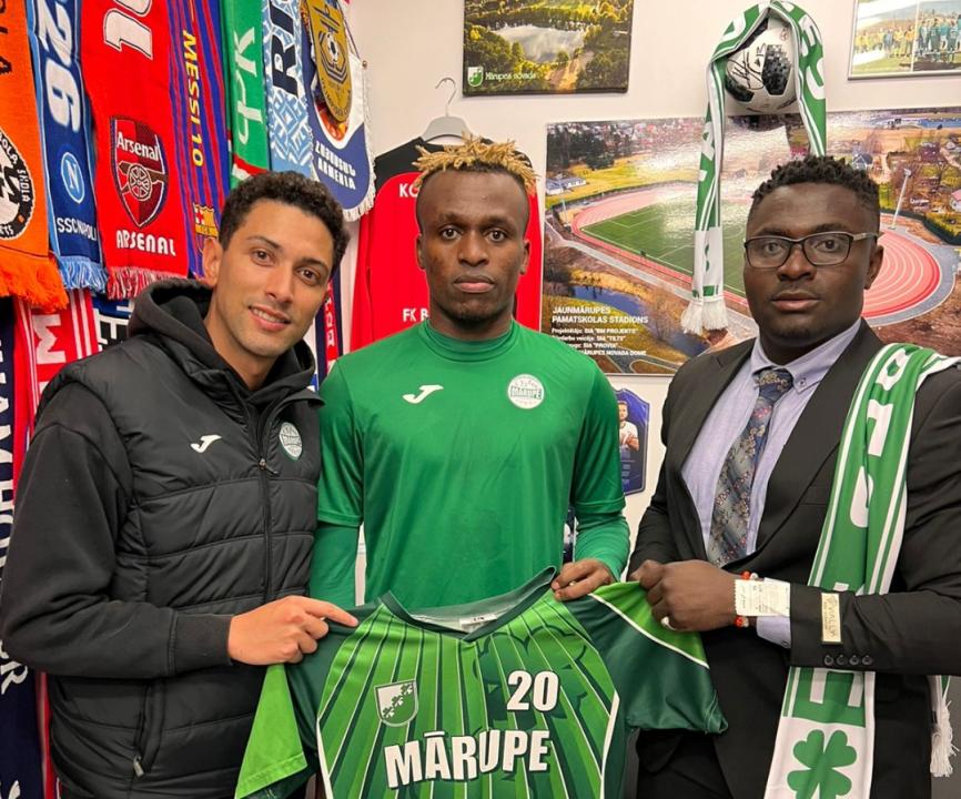 Un membre de Marupe SC, Pierre Okende et le manager Ernest Kyungu, lors de la signature du contrat.