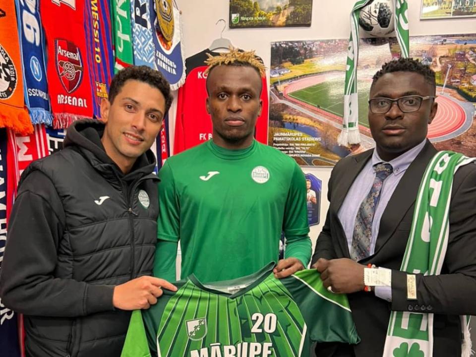 Un membre de Marupe SC, Pierre Okende et le manager Ernest Kyungu, lors de la signature du contrat.