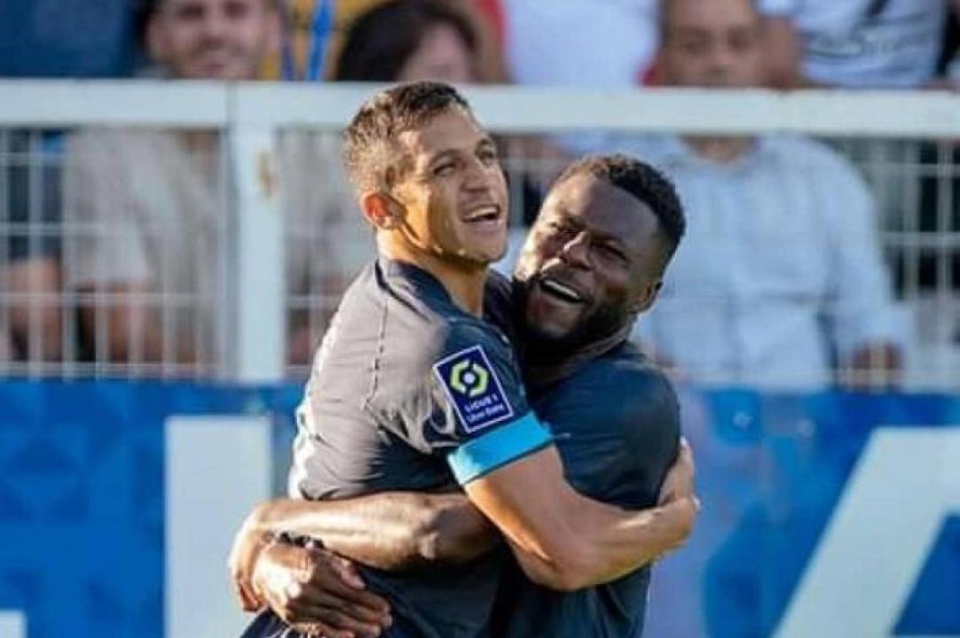Chancel Mbemba en pleine célébration d'un but avec Alexis Sanchez.