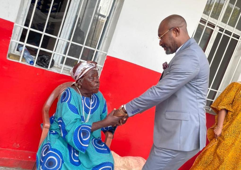 Jésus-Noël Sheke serrant très fort les bras d'une vieillarde au home des vieillards de Kabinda à Kinshasa