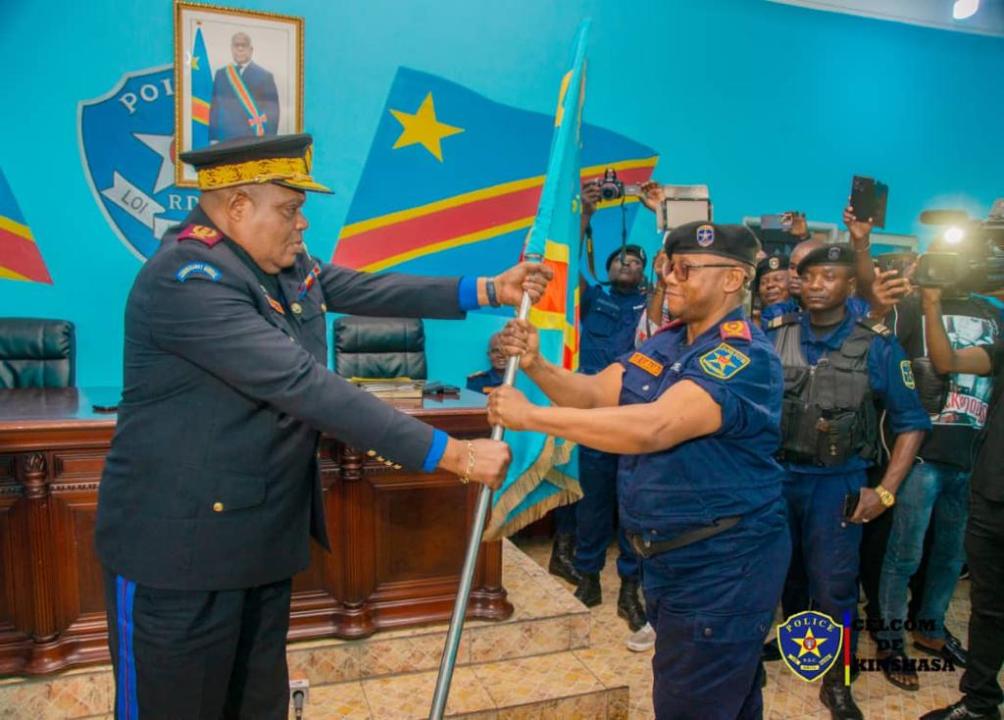 Le nouveau Commissaire provincial de Kinshasa, le Général Blaise Mbula Kilomba Limba reçoit le flambeau (drapeau du pays) des mains du commissaire Général de la police, le Général Patience Mushid Yav.